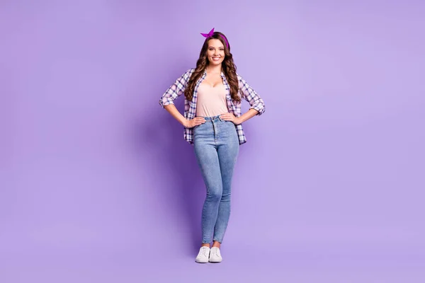 Полная длина фото женские руки бедра выглядят камера носить клетчатую рубашку ретро головной убор джинсы кроссовки изолированный фиолетовый цвет фона — стоковое фото