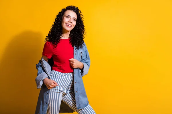 Foto de linda senhora olhar espaço vazio radiante sorriso desgaste listrado jeans vermelho t-shirt casaco isolado cor amarela fundo — Fotografia de Stock