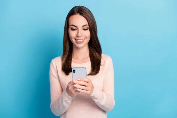 Foto van positief meisje lees social network feedback op smartphone slijtage pastel pullover geïsoleerd over blauwe kleur achtergrond — Stockfoto