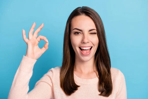 Photo of excited girl show okay symbol wink wear pastel pullover isolated over blue color background — Stock Photo, Image
