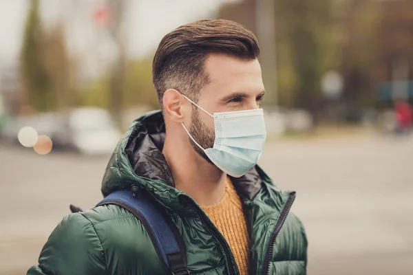 Profiel portret van jonge man kijk ver weg zak op schouder medische koude veiligheid masker gezondheidszorg buiten — Stockfoto