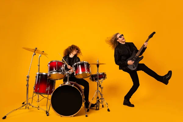 Full length photo funky crazy two people rock group team woman play drum man play bass guitar enjoy show event punk performance wear leather jacket isolated bright shine color background