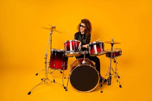Full size photo of famous rocker redhair lady plays instruments beat hands drum sticks concert hobby bring money wear black leather clothes sun glasses isolated yellow background