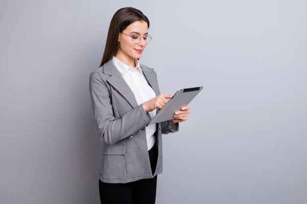 Foto av attraktiva affärskvinna säker chef arbetstagare använder modern teknik digital tablett arbete distans slitage specs skjorta rutig kavaj isolerad grå färg bakgrund — Stockfoto