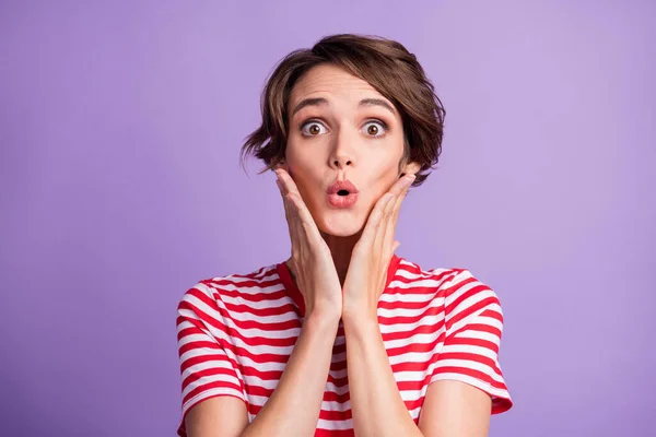 Foto von charmanten jungen Mädchen schockiert Ausdruck Arme Wangen tragen gestreifte T-Shirt isoliert violette Farbe Hintergrund — Stockfoto