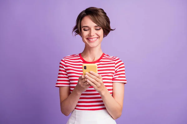 밝고 매력적 인 여성 이 전화기를 들고 있는 사진은 줄무늬 티셔츠외진 보라색 배경을 입고 있다. — 스톡 사진