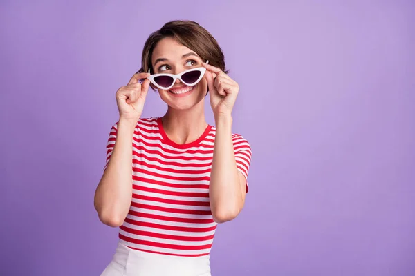 Fotografie mladé dívky vzlétnout specifikace podívat se do prázdného prostoru oblečení sluneční sklo pruhované tričko izolované fialové barvy pozadí — Stock fotografie