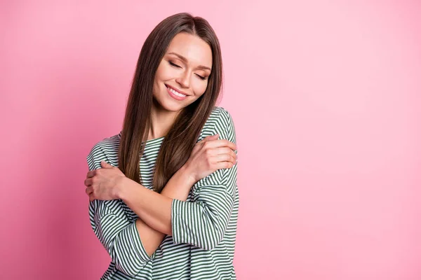 Фото прекрасной девушки с закрытыми глазами обнимается зубастая улыбка носить полосатую рубашку изолированный пастельно-розовый цвет фона — стоковое фото
