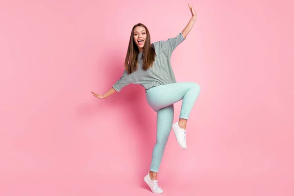 밝고 재미있는 여성 춤추는 사진의 전체 사이즈는 파스텔 핑크 색 배경에 고립된 파란색 바지 흰색 운동화를 착용 한다 — 스톡 사진
