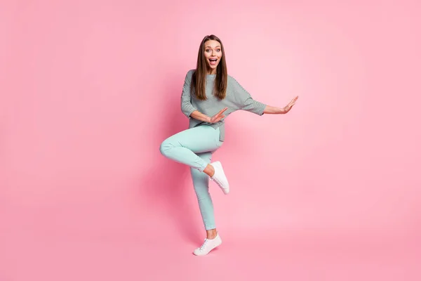Foto de tamaño completo de optimista dulce mujer bailando usar camisa pantalones azules zapatillas blancas aisladas sobre fondo de color rosa —  Fotos de Stock