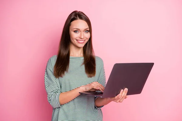 Foto de otimismo doce morena longo cabelo senhora trabalhando laptop desgaste casual t-shirt calças isoladas no fundo cor-de-rosa pastel — Fotografia de Stock