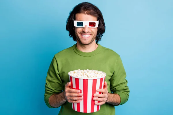 Foto van vrolijke jongen houden popcorn papier doos tandenstoker dragen 3D bril groen trui geïsoleerde blauwe kleur achtergrond — Stockfoto