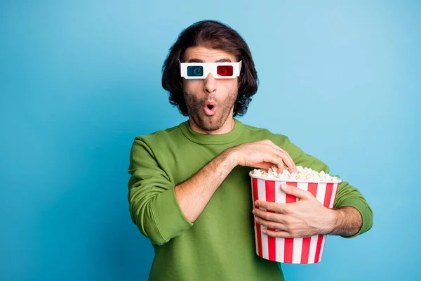 Foto van funky opgewonden man houden popcorn emmer open mond dragen 3d specs groene pullover geïsoleerde blauwe kleur achtergrond — Stockfoto