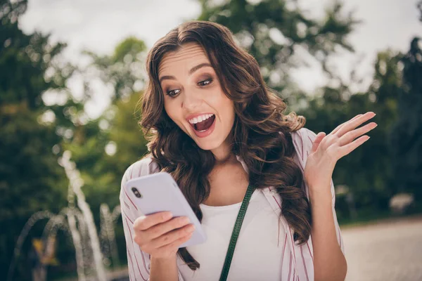 Foto portret van verbaasd verbaasd meisje kijken naar mobiele telefoon schreeuwen luid wandelen in groene stadspark — Stockfoto