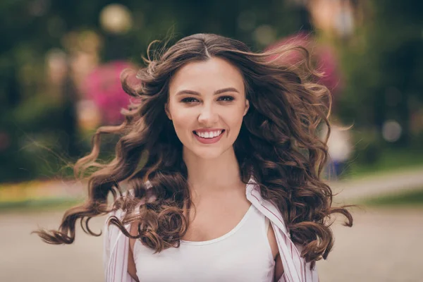 Photo portrait photo de belle fille jetant des cheveux par temps venteux se promenant dans le parc vert de la ville au printemps souriant joyeusement — Photo