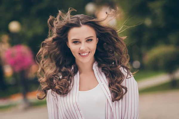 Foto retrato foto de chica bonita confiada lanzando pelo en el tiempo ventoso caminando por la calle —  Fotos de Stock