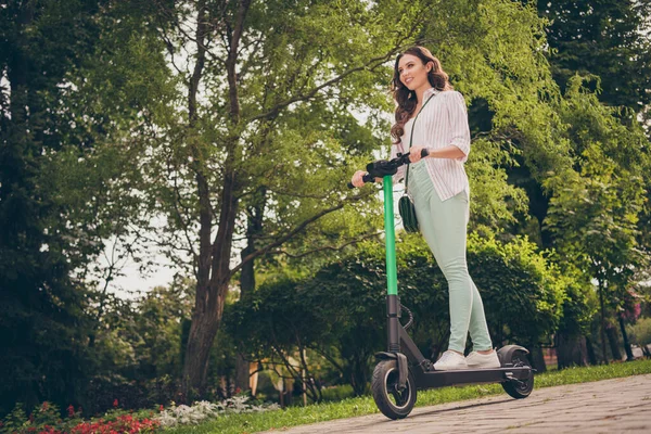 Alacsony szög nézet teljes test fotó elég boldog pozitív lány viseljen alkalmi ruhát lovagolni elektromos robogó a parkban szórakoztató élvezni — Stock Fotó