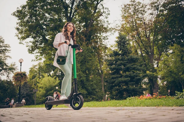 Vista de ángulo bajo foto cuerpo completo perfil lado de la chica positiva bastante feliz desgaste casual paseo traje scooter eléctrico en el parque eco descanso relajarse —  Fotos de Stock