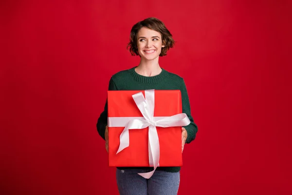 Ritratto di persona attraente braccia tenere giftbox sguardo spazio vuoto sorriso dentato isolato su sfondo di colore rosso — Foto Stock