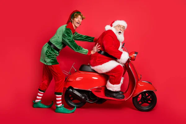 Lunghezza completa foto di due persone elfo Santa ride ciclomotore bloccato usura x-mas costume cappotto stivali cappuccio isolato colore rosso sfondo — Foto Stock