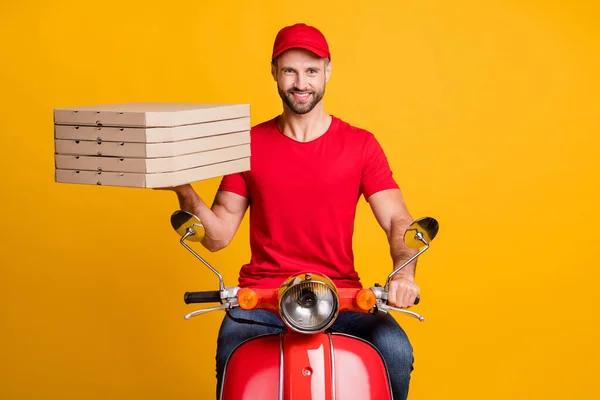 Fénykép a szállító srác futár lovagolni moped hold halom pizza dobozok viselnek piros póló sapka izolált sárga színű háttér — Stock Fotó