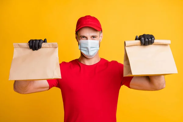 Photo of delivery guy hands hold karton csomagok kopás piros póló sapka kesztyű izolált sárga színű háttér — Stock Fotó