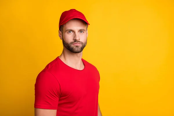 Φωτογραφία του ήρεμου bristled delivery man look κάμερα φορούν κόκκινο t-shirt καπέλο απομονωμένο κίτρινο χρώμα φόντο — Φωτογραφία Αρχείου