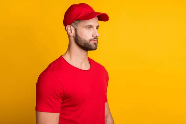 Φωτογραφία προφίλ του ήρεμου σοβαρού γενειοφόρου τύπου εξετάσουμε κενό χώρο φορούν κόκκινο t-shirt καπέλο απομονωμένο κίτρινο χρώμα φόντο — Φωτογραφία Αρχείου
