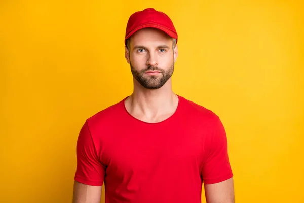 Foto di affascinante calma giovane uomo barbuto sguardo serio fotocamera indossare rosso t-shirt copricapi isolato colore giallo sfondo — Foto Stock
