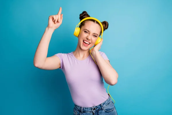 Photo of cheerful cool youngster lady two buns good mood listen modern earphones popular song excited dj dancing party wear casual purple t-shirt isolated blue color background — Stock Photo, Image