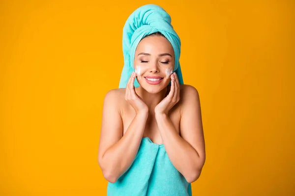 Foto von jungen lächelnden aufgeregten Frau Mädchen weiblichen geschlossenen Augen gelten Creme Lotion auf Gesicht isoliert auf gelbem Hintergrund — Stockfoto