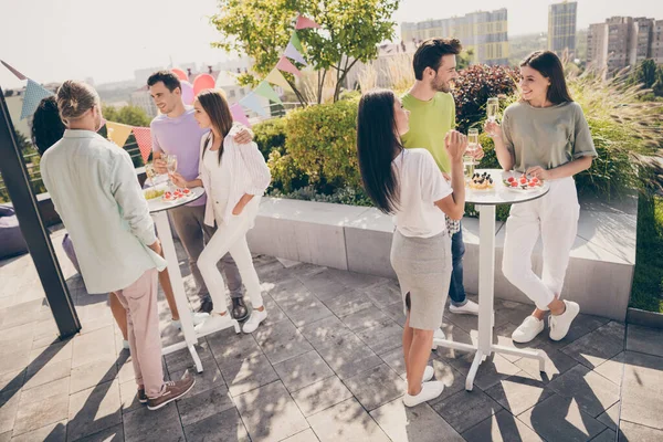 Full size photo of company of friends communicating hands hold champagne glass gathering restaurant outdoors