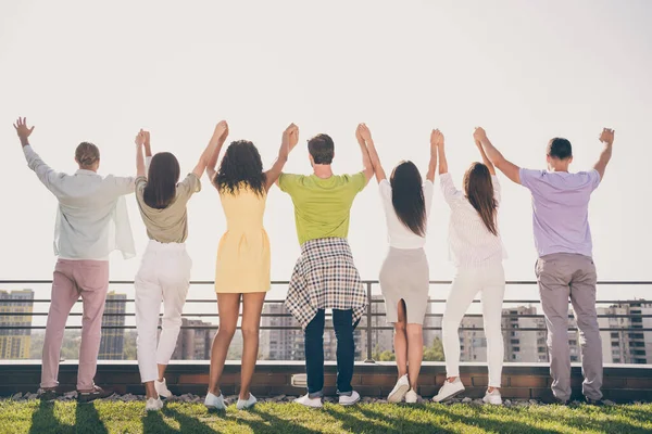 Foto de chicas bonitas optimistas chicos guapos de pie tomados de la mano divertirse fiesta en la azotea exterior — Foto de Stock