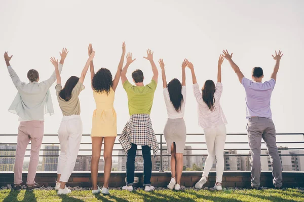 Foto de meninas bonitas engraçadas caras bonitos de pé mãos para cima ter festa divertida no terraço do telhado fora — Fotografia de Stock