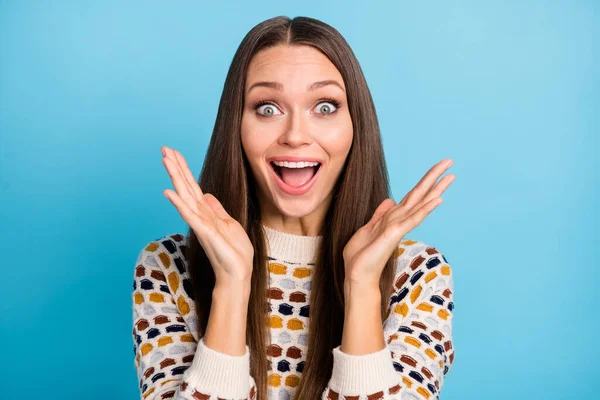 Foto von überrascht lustige junge Frau gekleidet Ornament Pullover steigende Arme Hände isoliert blaue Farbe Hintergrund — Stockfoto