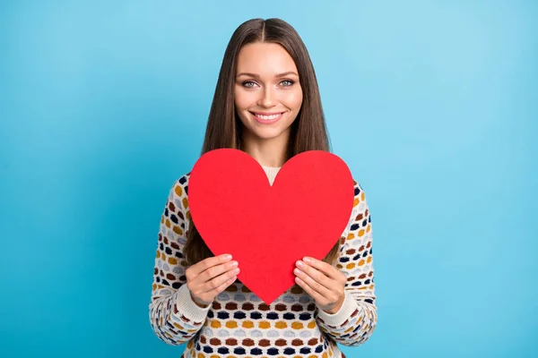 Foto de doce bonito jovem senhora desgaste ornamento suéter segurando vermelho papel coração isolado azul cor fundo — Fotografia de Stock