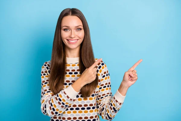 Foto de la encantadora joven bonita usar suéter ornamento señalando dos dedos espacio vacío aislado fondo de color azul — Foto de Stock