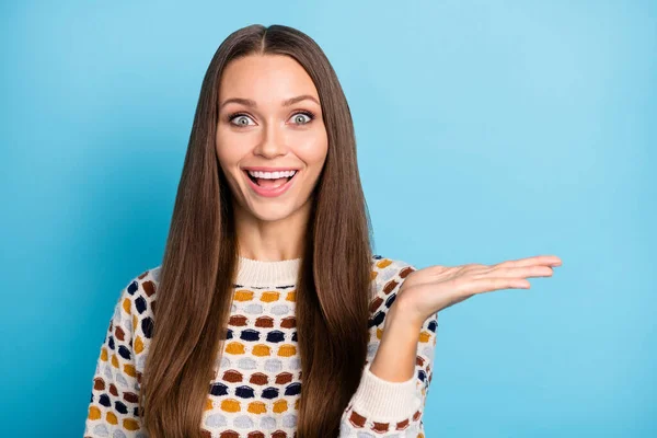 Foto de adorável impressionado jovem mulher vestido ornamento pulôver segurando braço vazio espaço isolado azul cor fundo — Fotografia de Stock