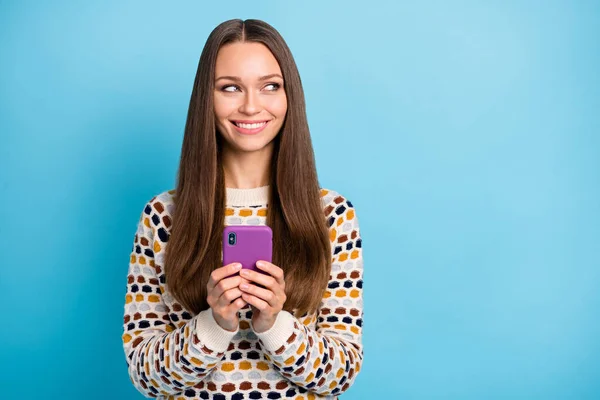 Foto de mulher jovem vestido ornamento pulôver mãos dispositivo moderno olhando espaço vazio isolado fundo cor azul — Fotografia de Stock