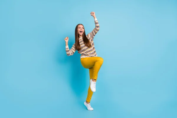 Foto van vrolijke gelukkige zoete jonge dame dragen ornament trui stijgende vuisten geïsoleerde blauwe kleur achtergrond — Stockfoto