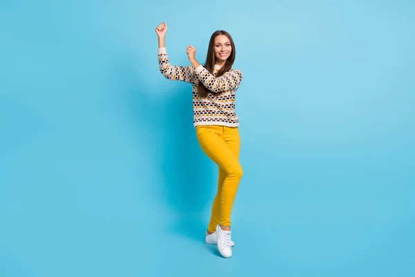 Foto de doce engraçado jovem senhora desgaste ornamento suéter levantando punhos isolado azul cor fundo — Fotografia de Stock