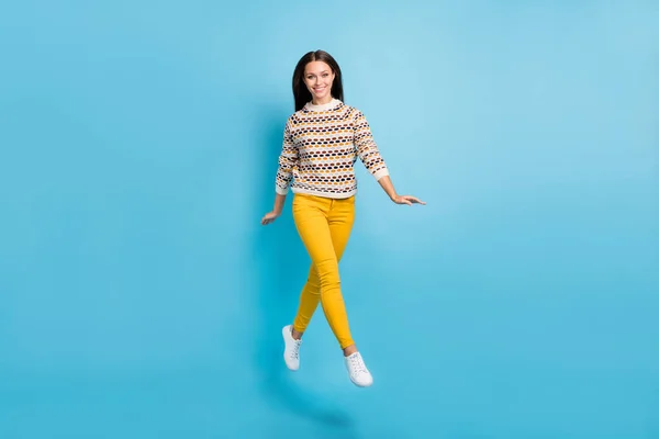 Pełna długość zdjęcie uroczej młodej kobiety ubrany ozdoba pullover jumping spacery odizolowany niebieski kolor tło — Zdjęcie stockowe