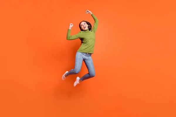 Teljes test fotó a fiatal izgatott lány ünneplik győzelem cél öklök kéz ugrás elszigetelt felett narancs színű háttér — Stock Fotó