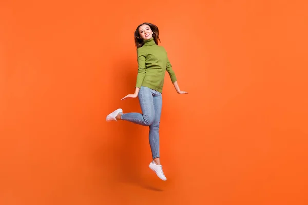 매력적 인 활기차게 웃는 젊은 소녀의 전신 사진 오렌지 색 배경 위로 고립 된 채솟아오르고 있다 — 스톡 사진