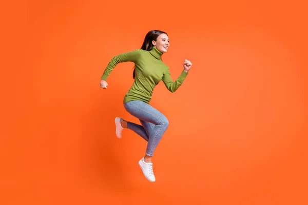 Teljes test profil oldalán fotó a fiatal vonzó őrült lány boldog mosoly fuss ugrás felfelé néz üres tér elszigetelt narancssárga szín háttér — Stock Fotó