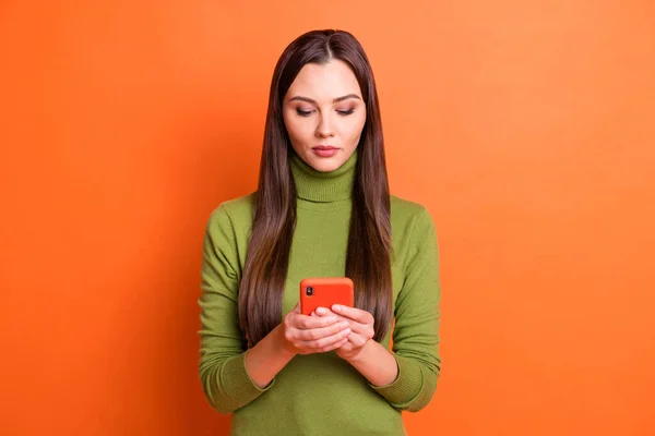 Foto van jong mooi ernstig kalm charmant mooi meisje gebruik telefoon chatten geïsoleerd op oranje kleur achtergrond — Stockfoto