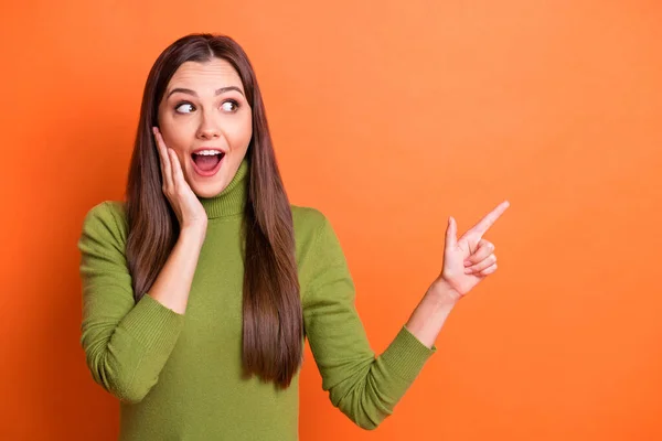 Foto av ung attraktiv glad chockad förvånad flicka hålla hand kind peka finger copyspace isolerad på orange färg bakgrund — Stockfoto