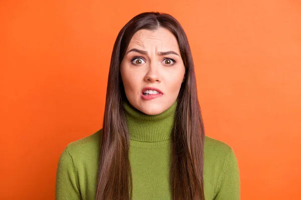 Portret van onder de indruk gestresst brunette kapsel meisje bijtende lippen dragen groene trui geïsoleerd op pompoen kleur achtergrond — Stockfoto