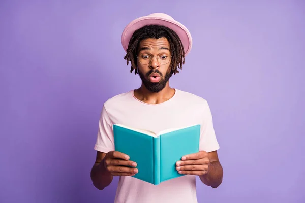 Foto do jovem africano chocado surpreso homem bonito cara segurar ler diário azul isolado no fundo cor violeta — Fotografia de Stock