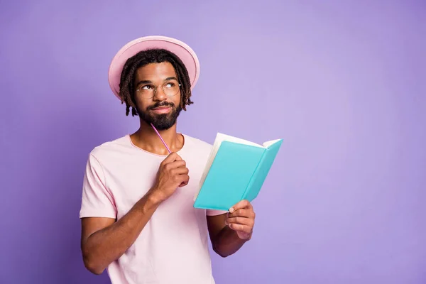 Foto van jonge Afrikaanse dromerige glimlachende knappe man mannelijke man kijken copyspace hold blauw dagboek geïsoleerd op paarse kleur achtergrond — Stockfoto